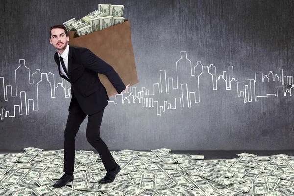 Businessman carrying bag of dollars — Stock Photo, Image