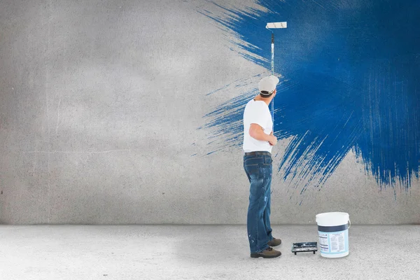 Hombre usando rodillo de pintura sobre fondo blanco — Foto de Stock