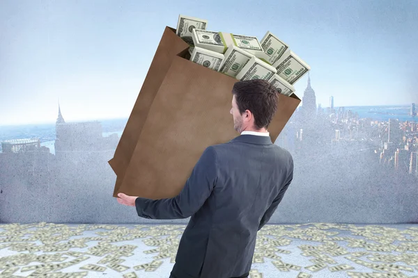 Businessman carrying bag of dollars — Stock Photo, Image