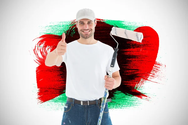 Hombre feliz con rodillo de pintura gestos pulgares hacia arriba — Foto de Stock