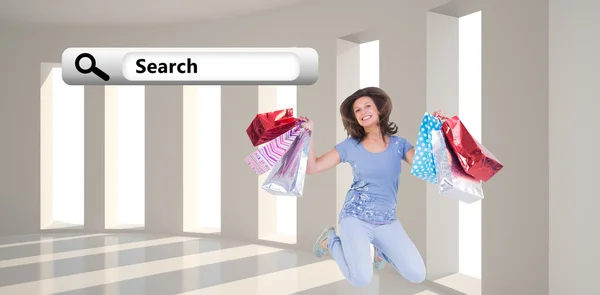 Brunette springen terwijl shopping tassen — Stockfoto