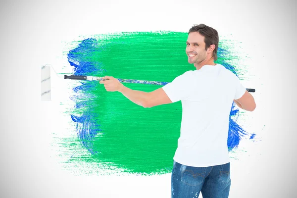 Hombre feliz usando rodillo de pintura — Foto de Stock