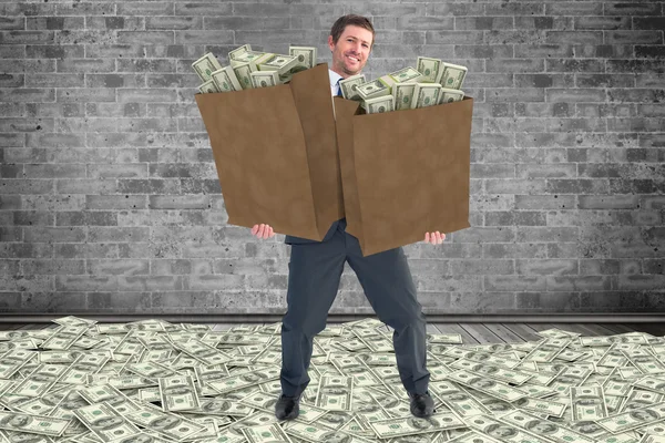 Businessman carrying bags of dollars — Stock Photo, Image