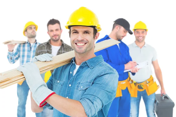 Happy carpenter carrying wooden planks — Stock Photo, Image