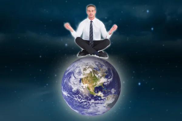 Composite image of businessman meditating in lotus pose — Stock Photo, Image