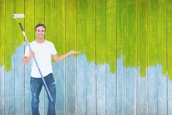 Man gesturing while holding paint roller — Stock Photo, Image