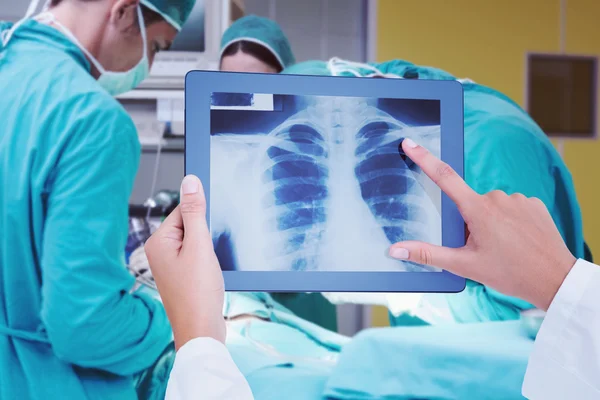 Imagen compuesta del médico mirando rayos X en el comprimido — Foto de Stock