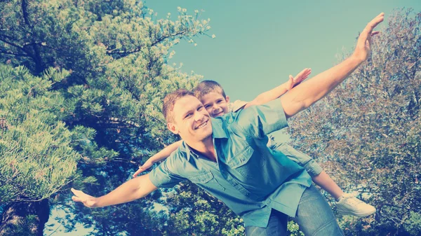 Hijo jugando con su padre fuera —  Fotos de Stock