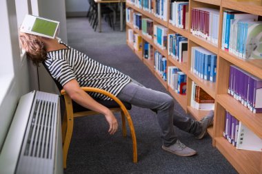 Student asleep with book on his face clipart