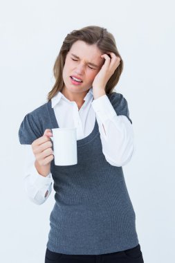 Woman with headache holding mug  clipart