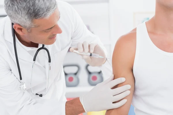 Doctor doing an injection to his patient — Stock Photo, Image