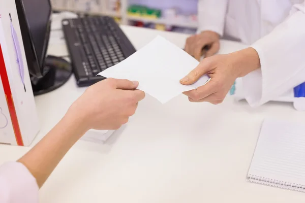 Pharmacist giving prescription to costumer — Stock Photo, Image