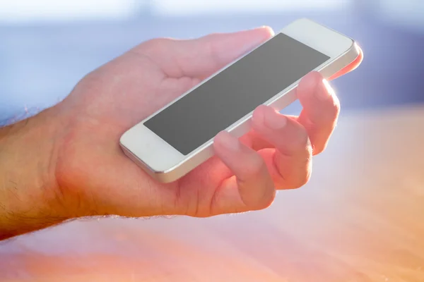 Ręka trzymająca biały smartfon — Zdjęcie stockowe