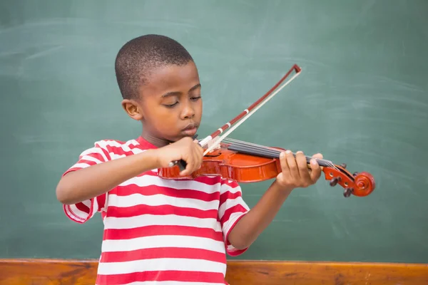 Милый ученик играет на скрипке в классе — стоковое фото