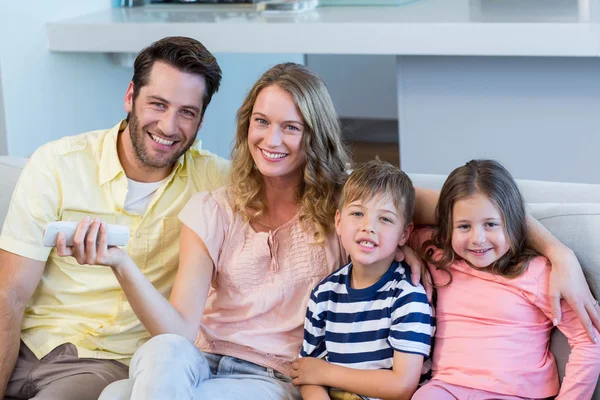 Счастливая семья на диване смотрит телевизор — стоковое фото