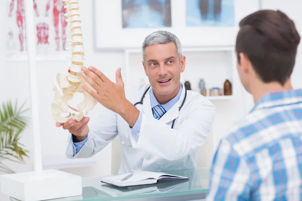 Доктор показує пацієнту модель хребта — стокове фото