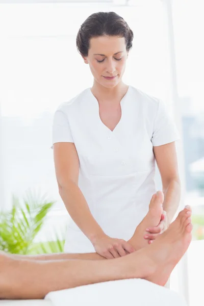 Fisioterapista che fa massaggi ai piedi — Foto Stock