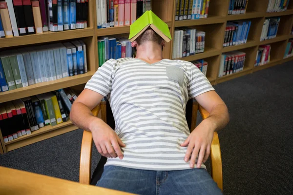 Estudante dormindo com livro em seu rosto — Fotografia de Stock