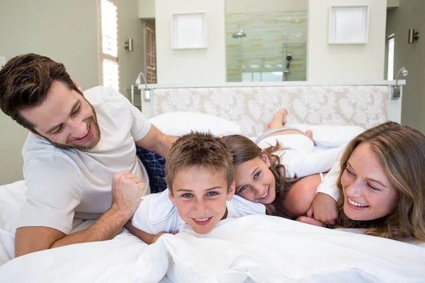 Glückliche Familie spielt auf dem Bett — Stockfoto
