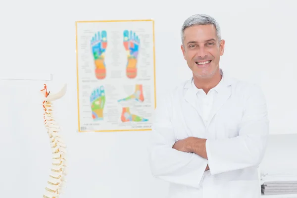 Médico sonriendo con los brazos cruzados — Foto de Stock