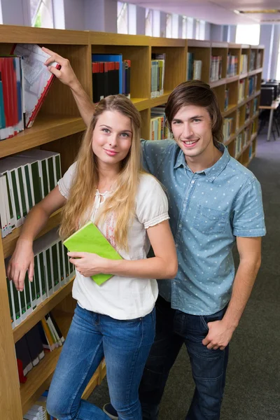 Φοιτητές που χαμογελάει σε κάμερα στη βιβλιοθήκη — Φωτογραφία Αρχείου
