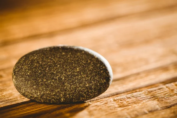 Pebble on a wooden table — Stock Photo, Image