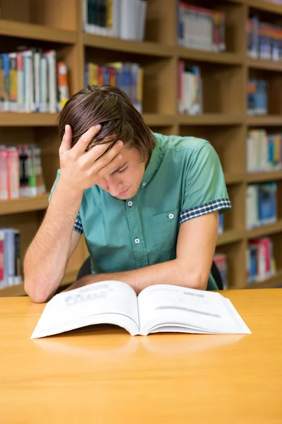 Estudante sentado em leitura de biblioteca — Fotografia de Stock