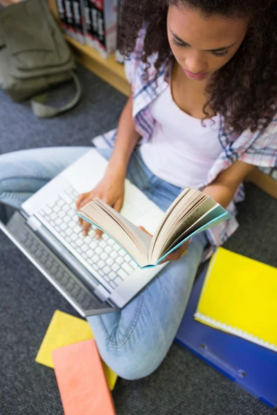 Студент у бібліотеці за допомогою ноутбука — стокове фото