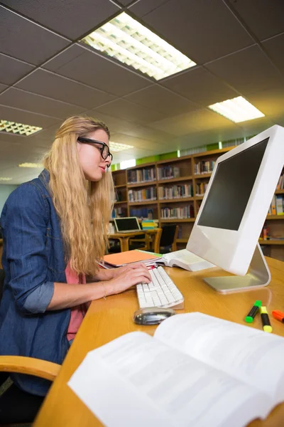 Φοιτητής που σπουδάζει στη βιβλιοθήκη με υπολογιστή — Φωτογραφία Αρχείου