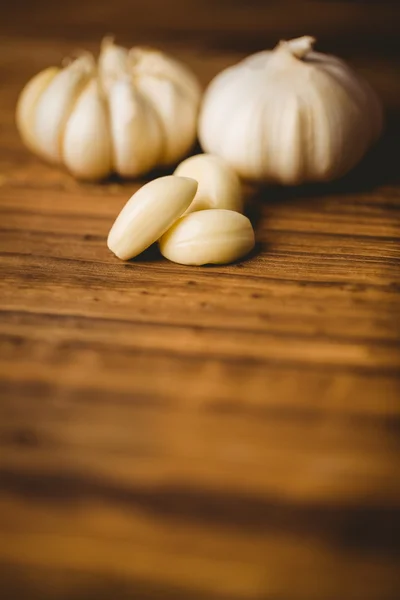 Garlic cloves and bulb on chopping board — Stock Photo, Image