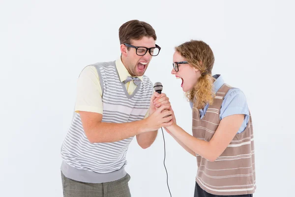 Geeky hipster coppia che canta in un microfono — Foto Stock