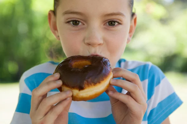 Мила дівчинка їсть пончик — стокове фото