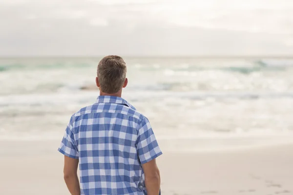 Uomo casual che guarda verso il mare — Foto Stock