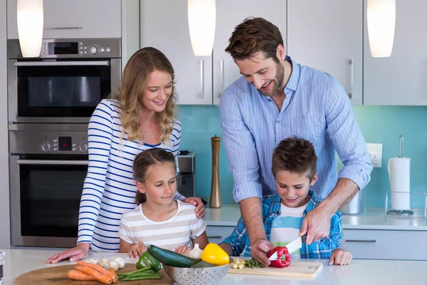 Familia feliz preparando verduras juntos — Foto de Stock