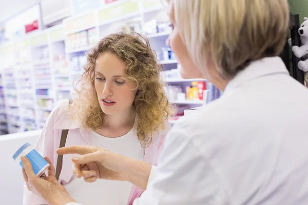 Apotekare och kund talar om medicinering — Stockfoto