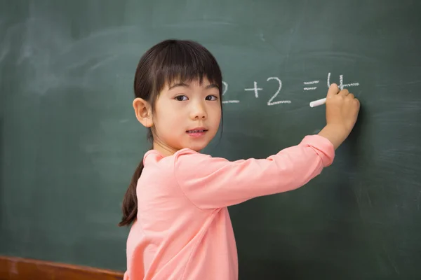 Leerling schrijven van nummers op een schoolbord — Stockfoto