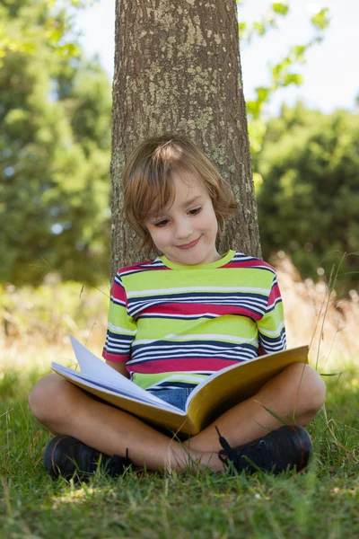 Kleiner Junge liest im Park — Stockfoto