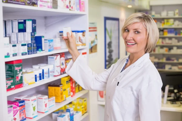 Pharmacist taking medicine from shelf — Stock Photo, Image