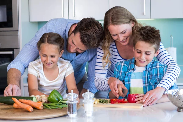 Família feliz preparando legumes juntos — Fotografia de Stock