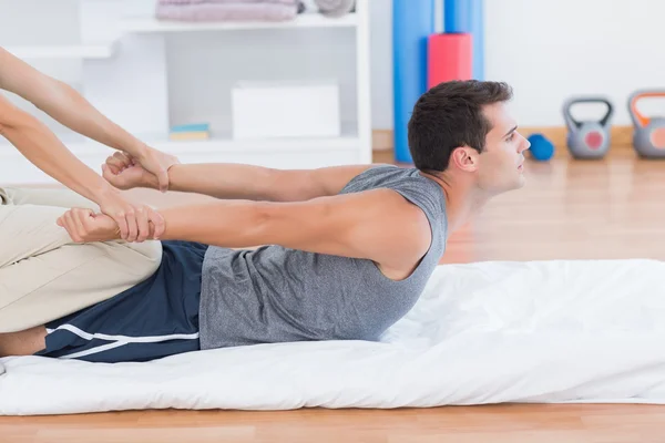 Hombre estirándose con su entrenador — Foto de Stock