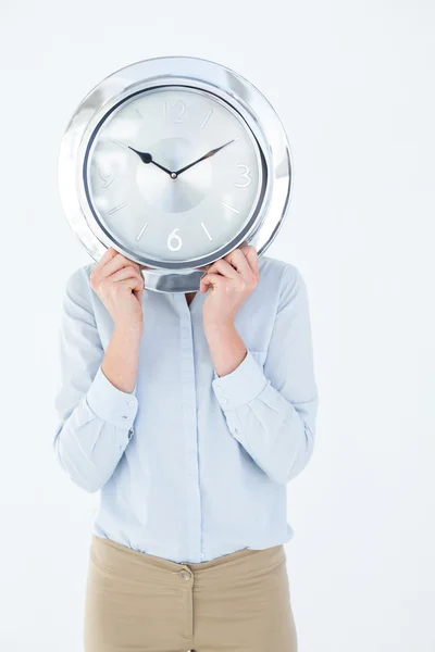 Empresária de terno segurando um relógio — Fotografia de Stock