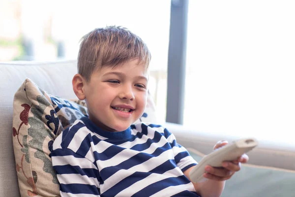 Kleiner Junge vor dem Fernseher auf der Couch — Stockfoto