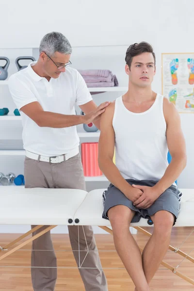 Médico examinando seu ombro paciente — Fotografia de Stock