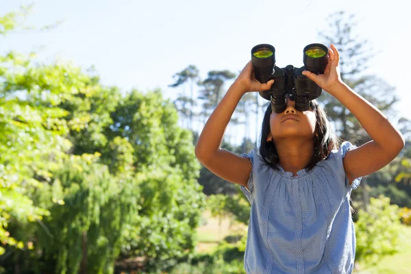 Cute little girl looking through binoculars — Stock Photo, Image