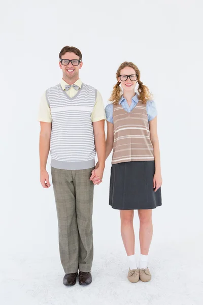 Smiling geeky hipster couple holding hands — Stock Photo, Image