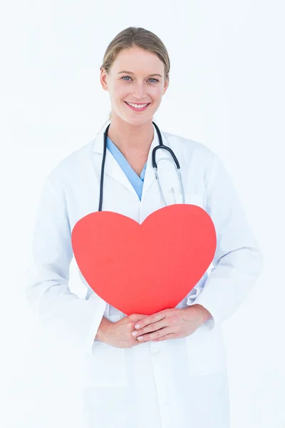 Doctor sosteniendo tarjeta roja del corazón — Foto de Stock