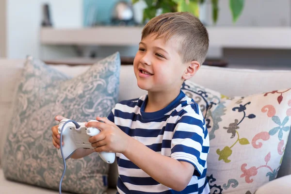 Kleine jongen spelen van videogames op de Bank — Stockfoto