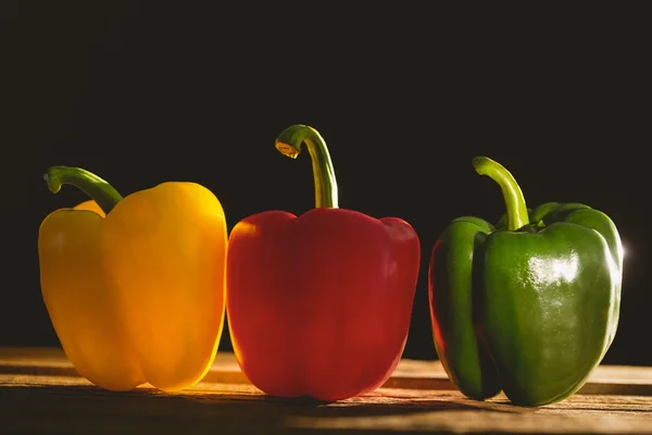 Trois poivrons sur planche à découper — Photo