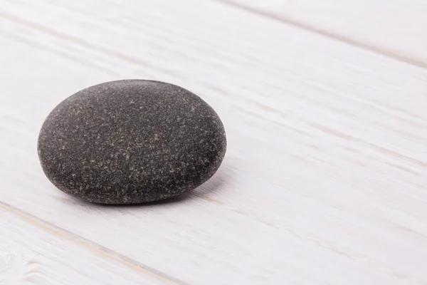 Pebble on a wooden table — Stock Photo, Image