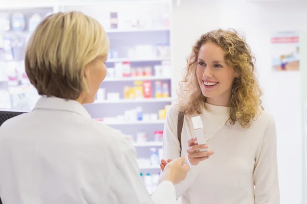 Costumer mostrando frasco de medicina a farmacéutico — Foto de Stock